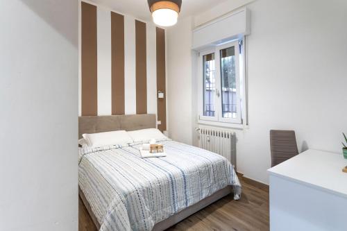 a white bedroom with a bed and a window at Casa San Paolo - Pavia Città - by Host4U in Pavia