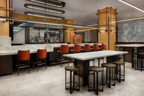 a bar with orange chairs and tables in a restaurant at The Westin Denver Downtown in Denver
