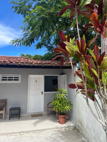 a house with a white door and some plants at Pousada El Camenito Geribá Búzios in Búzios