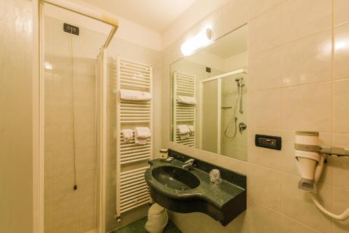 a bathroom with a black sink and a shower at Hotel Au Soleil in Saint Vincent