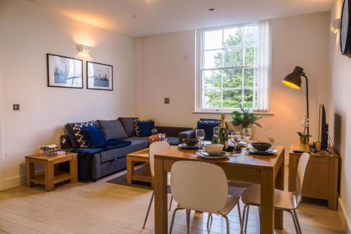 a living room with a table and a couch at Cozy Entire Flat with Gated Parking- Contractors, Family, Groups in Reading