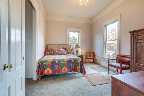 een slaapkamer met een bed, een stoel en ramen bij Eclectic Sacramento Home about Half Mi to Downtown! in Sacramento