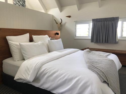 a large white bed with white sheets and pillows at Indigo Charlee in Gold Coast