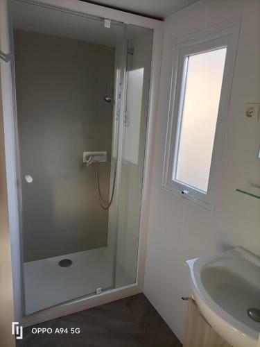 une salle de bain avec douche et lavabo dans l'établissement Camping la Cacabasse, à Vias