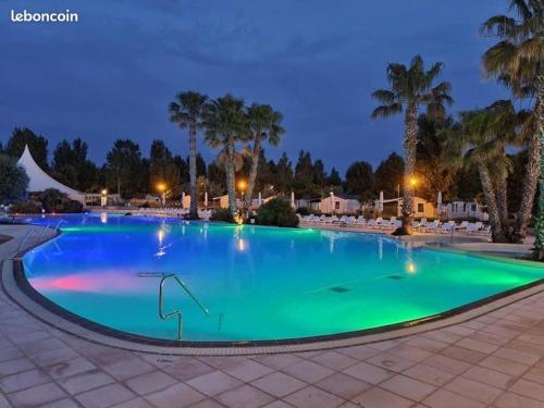 - une grande piscine d'eau verte la nuit dans l'établissement Camping la Cacabasse, à Vias
