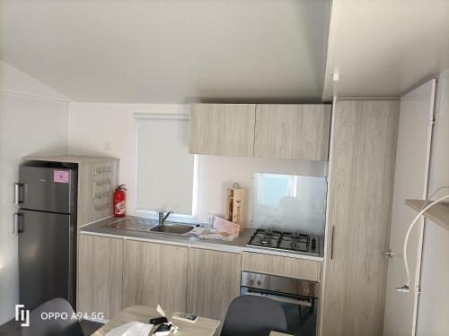 Il comprend une petite cuisine équipée d'une cuisinière et d'un réfrigérateur. dans l'établissement Camping la Cacabasse, à Vias