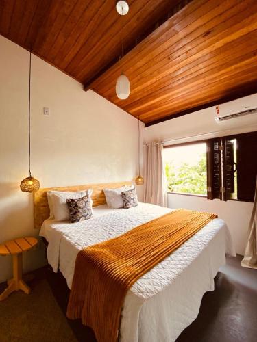 um quarto com uma cama grande e uma janela em Casa Vida Li na Ilha de Boipeba