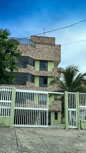 a building with a white gate in front of it at FLAT NA PRAIA DO MEIO in São-José-do-Ribamar