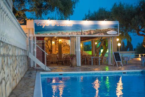 un hotel con piscina frente a un restaurante en Paradisus Apartments, en Barbati