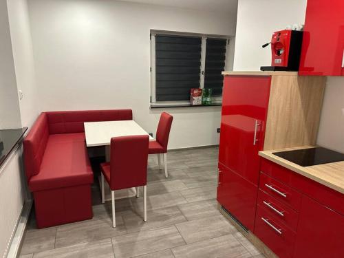 a kitchen with a red couch and a table and chairs at Ferienwohnung in Wilhermsdorf