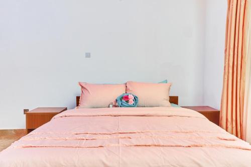 a bedroom with a large bed with pink sheets at Modern 3 Bed Spacious Apartments in Adentan