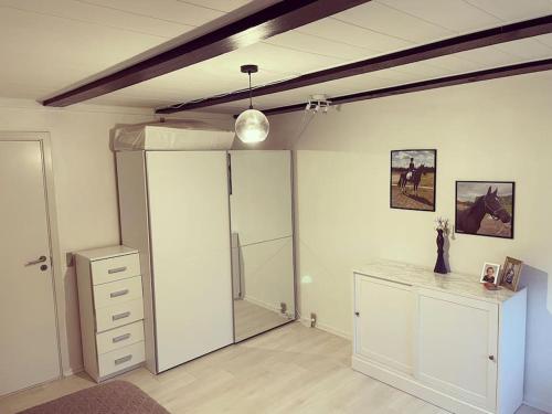 um quarto com uma cozinha com um balcão e um frigorífico em Lejlighed med tagterrasse, have og pool. em Vipperød