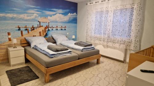 1 dormitorio con 1 cama y una pintura de un muelle en Ferienhaus Guldner mit Terrasse, Garten und Sauna, en Überherrn