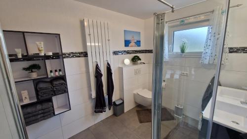 ein Bad mit einer Dusche und einem WC in der Unterkunft Ferienhaus Guldner mit Terrasse, Garten und Sauna in Überherrn
