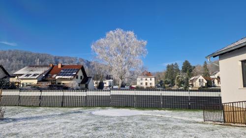 a fence in front of a house with solar panels at Ferienhaus Guldner mit Terrasse, Garten und Sauna in Überherrn