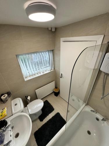 uma casa de banho com um lavatório, uma banheira e um WC. em West Midlands Contractors, Nurses and Families 