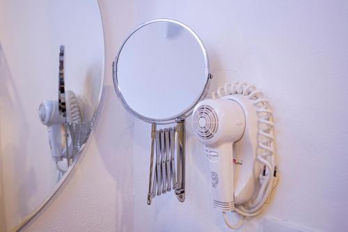 a hair dryer and a mirror hanging on a wall at Pousada Cavaleiro dos Pireneus in Pirenópolis