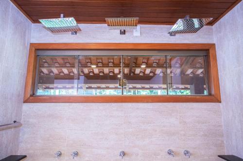 a glass window in a bathroom with a sink at Pousada Cavaleiro dos Pireneus in Pirenópolis