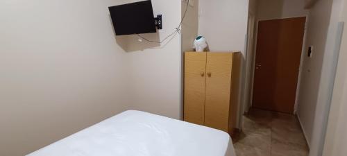 1 dormitorio con 1 cama, TV y armario en Tierra Mía, en Posadas