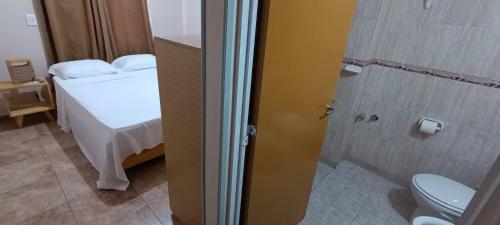 uma casa de banho com uma cama e um chuveiro com um WC em Tierra Mía em Posadas
