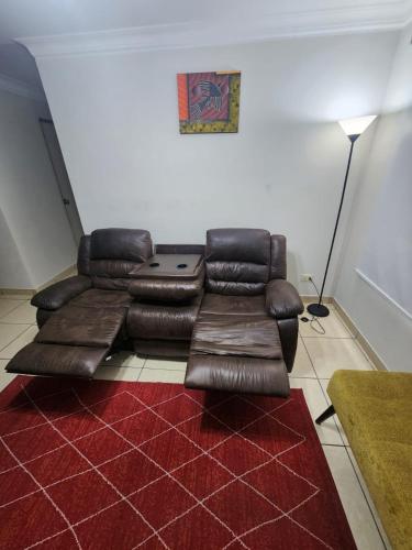 a leather couch in a living room with a red rug at rodrich business apartment in Lima