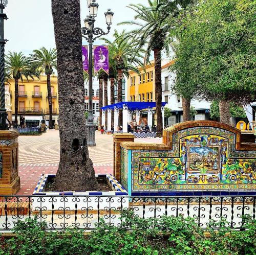 a mosaic bench next to a tree with a fence at Estudio Colón in Ayamonte