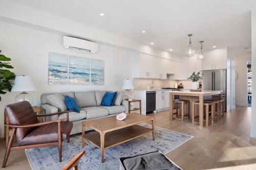 a living room and kitchen with a couch and a table at Ocean's 7 at THE BEACH HOUSE in Campbell River