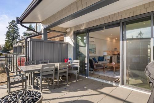 a patio with a table and chairs on a house at Ocean's 7 at THE BEACH HOUSE in Campbell River