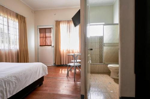 um quarto com uma cama e uma casa de banho com um WC em La Casa de Algodon em Huacho