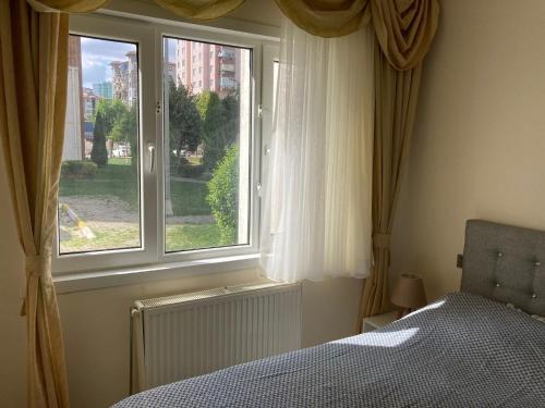 um quarto com uma cama e uma grande janela em Cozy Apartment in a Popular Neighborhood em Çorlu