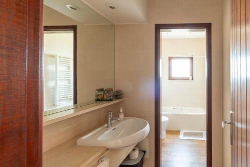 een badkamer met een wastafel en een spiegel bij Beach House w/ Pool Kid Friendly in Sintra