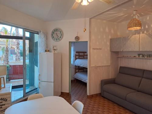 - un salon avec un canapé et un réfrigérateur dans l'établissement Location appartement bord de mer Barcarès, au Barcarès