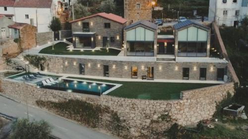 una vista aérea de una casa con una pared de piedra en SERRA en Cortes do Meio