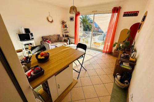 a kitchen with a table and a living room at Charming well-equipped apartment with wifi in Bordeaux