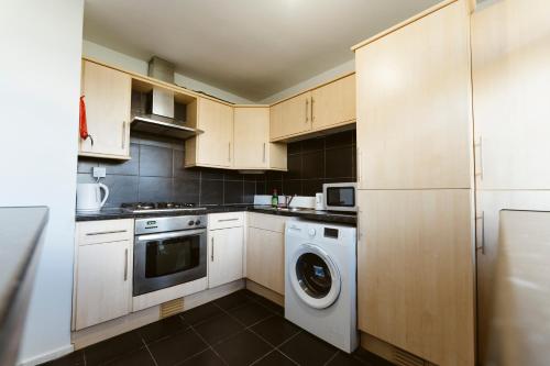 a kitchen with a washing machine and a washer at Langdon Park Room in London