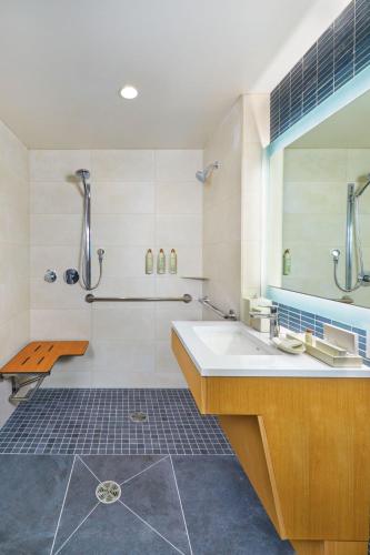 a bathroom with a tub and a sink and a shower at Renaissance Honolulu Hotel & Spa in Honolulu
