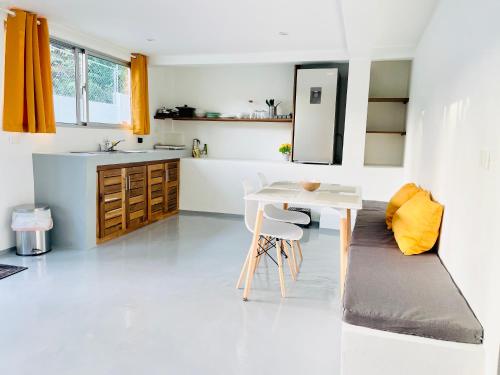a white kitchen with a white table and a sink at Cozy Studio in Private Villa in Las Terrenas