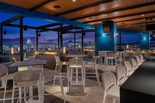 a restaurant with tables and chairs and a view of the city at AC Hotel by Marriott Washington DC Capitol Hill Navy Yard in Washington