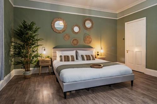 una camera da letto con un letto e due specchi sul muro di Clarence Square Penthouse 