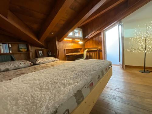 1 dormitorio con 1 cama grande y escritorio en Mansarda nel centro di Cortina, en Cortina dʼAmpezzo