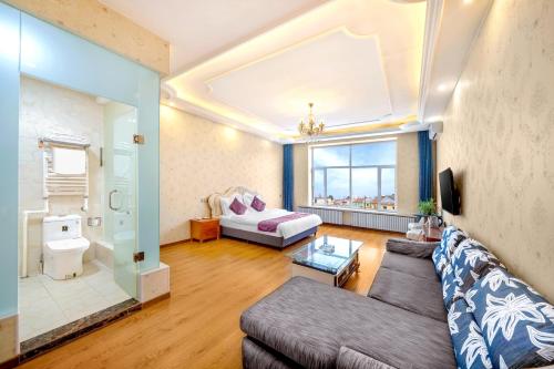 een woonkamer met een bank en een raam bij Harbin Binpeng Inn - Harbin Taiping International Airport in Taipingzhuang
