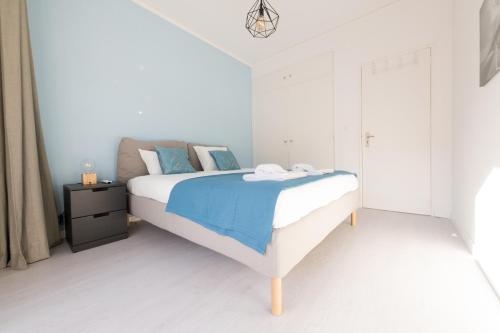 オエイラスにあるOeiras Sweet Flatの白いベッドルーム(青いシーツ付きのベッド1台付)