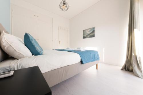 オエイラスにあるOeiras Sweet Flatの白いベッドルーム(青い枕のベッド付)