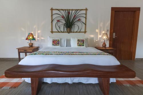 um quarto com uma grande cama branca e 2 candeeiros em Resort Fazenda 3 Pinheiros em Engenheiro Passos