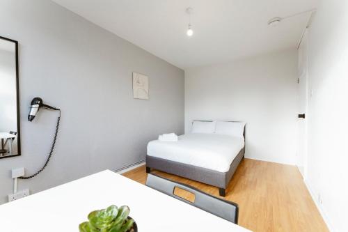 a small bedroom with a bed and a mirror at Langdon Park Room in London