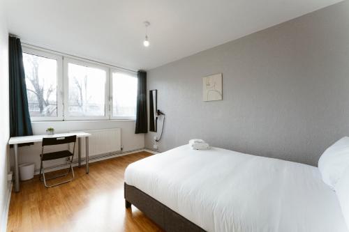a bedroom with a bed and a desk and a window at Langdon Park Room in London