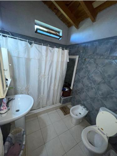 y baño con aseo, lavabo y ducha. en Departamento en maipu en Maipú