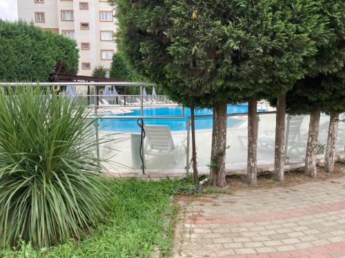 un grupo de sillas sentadas junto a una piscina en Cozy Apartment in a Popular Neighborhood en Corlu