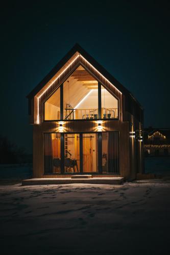 a house with a large window at night at Zielone Wzgórze komfortowy klimatyzowany domek z balią z aeromasażem in Kłodzko