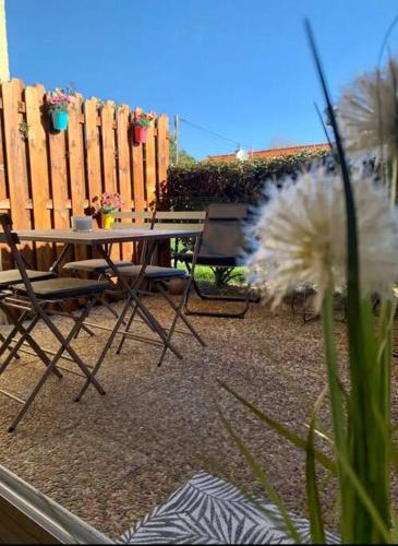 un patio avec une table et des chaises et une clôture dans l'établissement Studio du port avec terrasse, parking privatif, piscine dans résidence , wifi, ménage compris, à Andernos-les-Bains